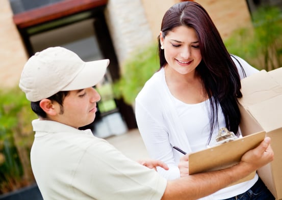 Woman receiving a package at home from a delivery guy